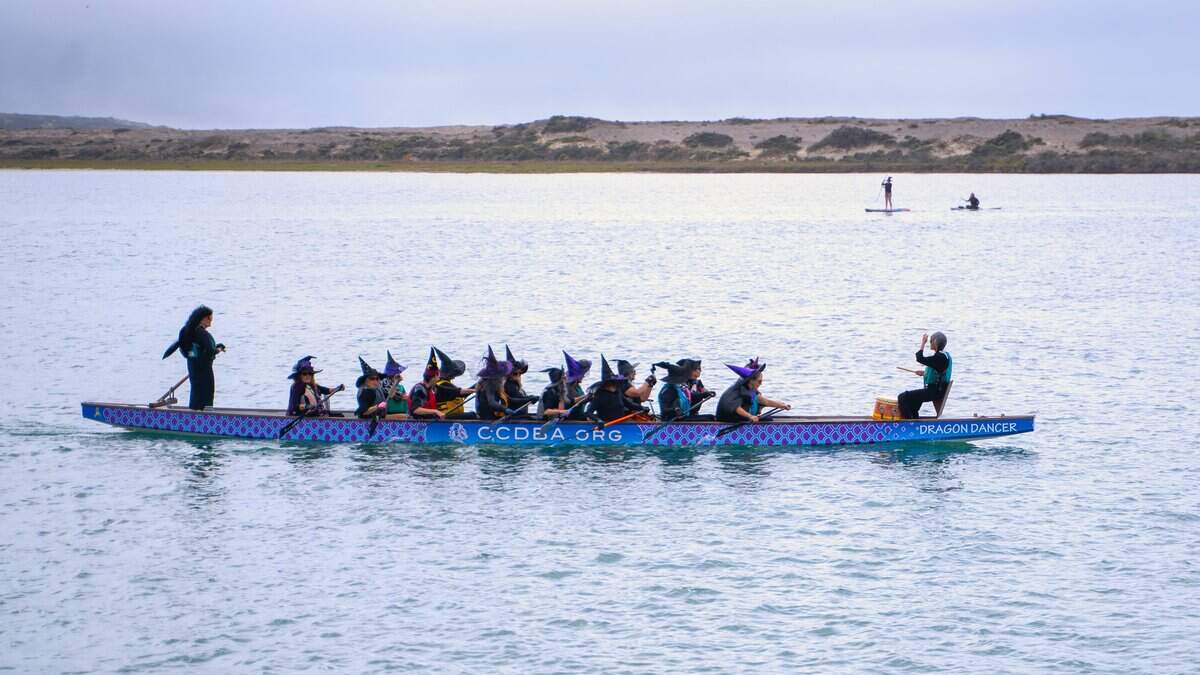 A team of withces rows a longboat at the Witches Paddle in Morro Bay on Saturday, Oct. 25, 2025. The 13th annual paddle attracted hundreds of witches and creatures of the night taking to the watter on paddleboards, kayaks and other small craft.