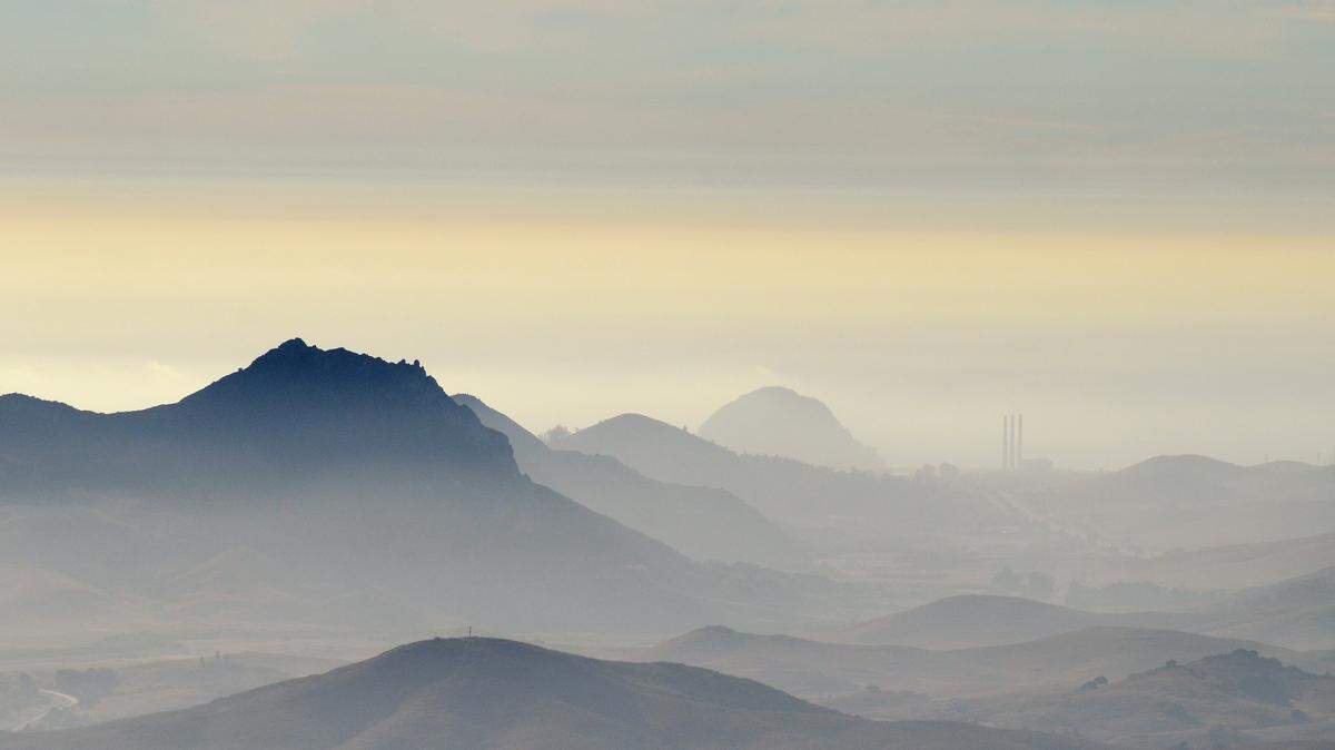 A hazy sky cast over mountains facing Morro Bay.