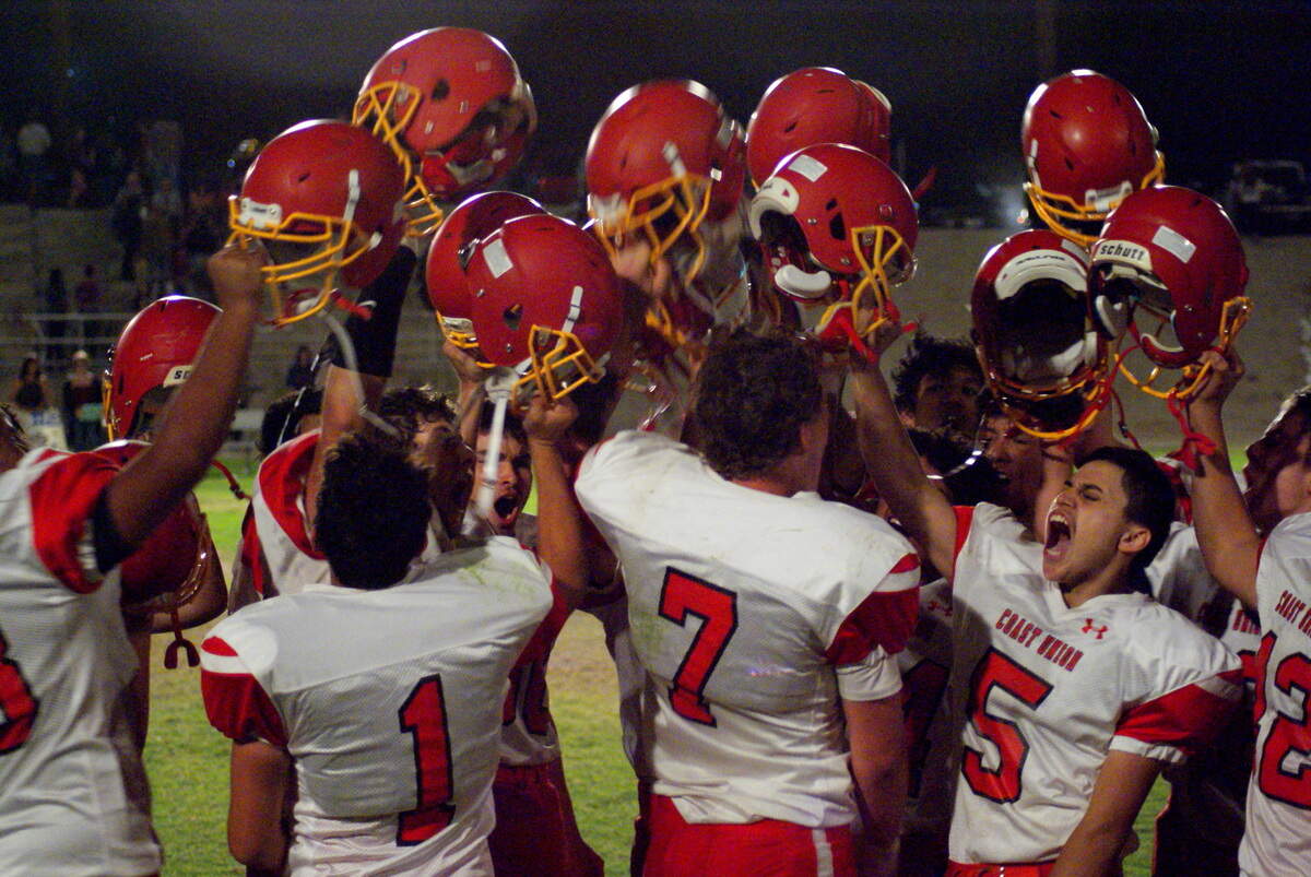 Coast Union High School players raise helmets high in the air after a victory over league opponent Maricopa.