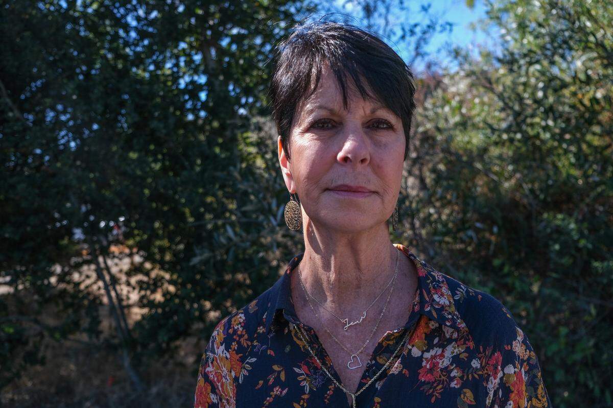 Pati Blevins wears a necklace with her daughter’s name to the memorial for her daughter, Jennifer Besser, and her daughter’s boyfriend, Matthew Chachere in San Luis Obispo on Oct. 21, 2023. Besser and Chachere were killed by a vehicle in November 2022.