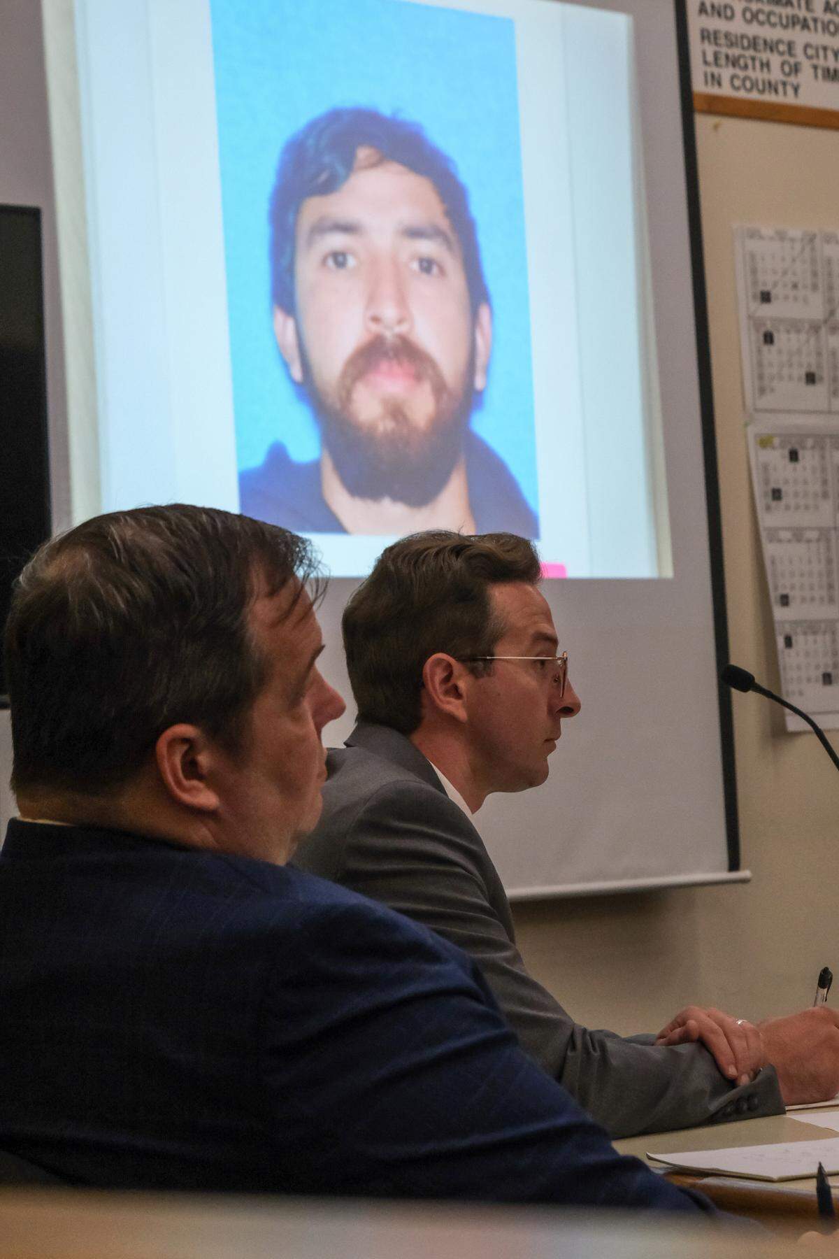 Nate Abate, center attends the criminal trial against him with his defense attorney, Scott Taylor, in San Luis Obispo Superior Court on Oct. 9, 2024. Abate is charged with oral copulation of a minor, rape by intoxication and two counts of rape by force — all felonies. On the screen behind Abate is a photo of Julian Contreras, who fled the country after being accused of multiple sexual assaults with Abate.