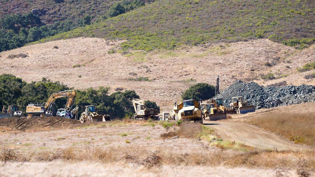 Mining vehicles harvest Franciscan melange, a stone found at the base of Bishop Peak, from a quarry off Foothill Boulevard on Thursday, Aug. 15, 2024. The quarry sits on Madonna Ranch land and is supplying materials for John Madonna Construction’s Highway 1 repair efforts along the Big Sur coast.