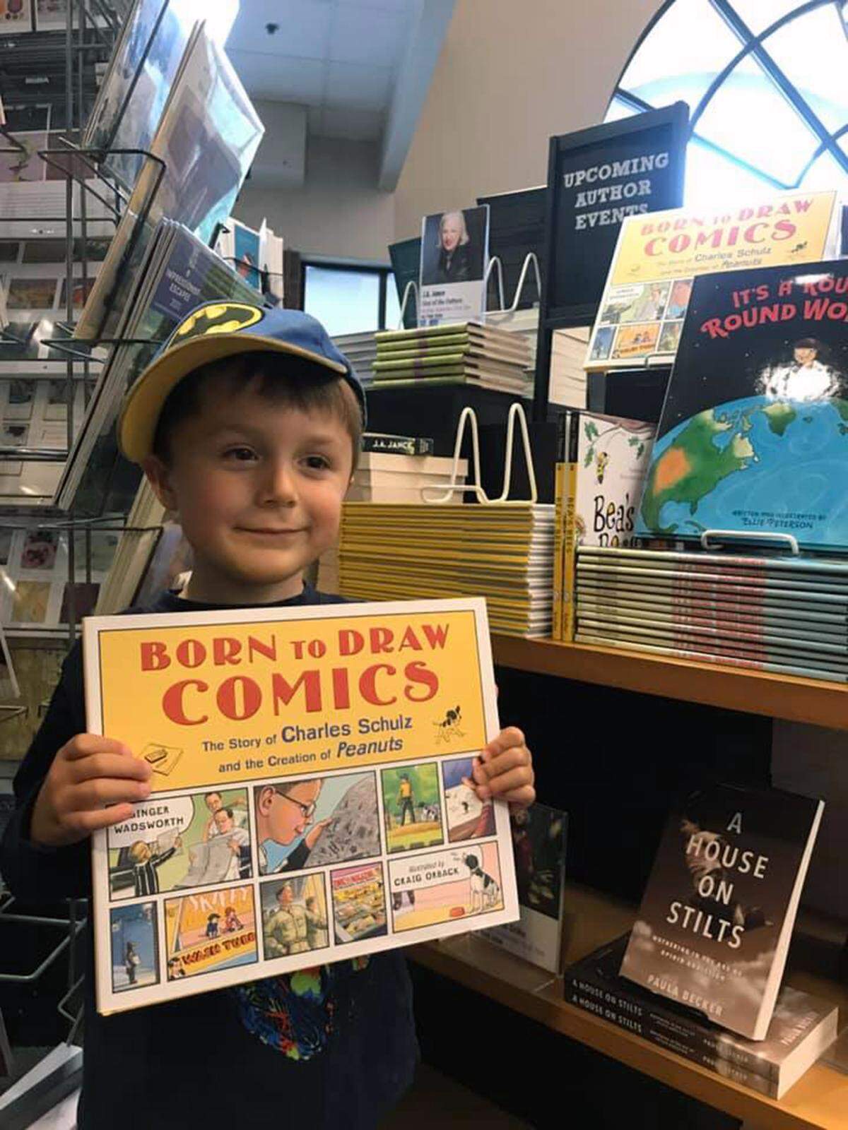 Illustrator Craig Orback’s son, Lewis, with a copy of “Born to Draw Comics: The Story of Charles Schulz and the Creation of Peanuts,” written by Ginger Wadsworth and illustrated by Orback, at Seattle-area bookstore.