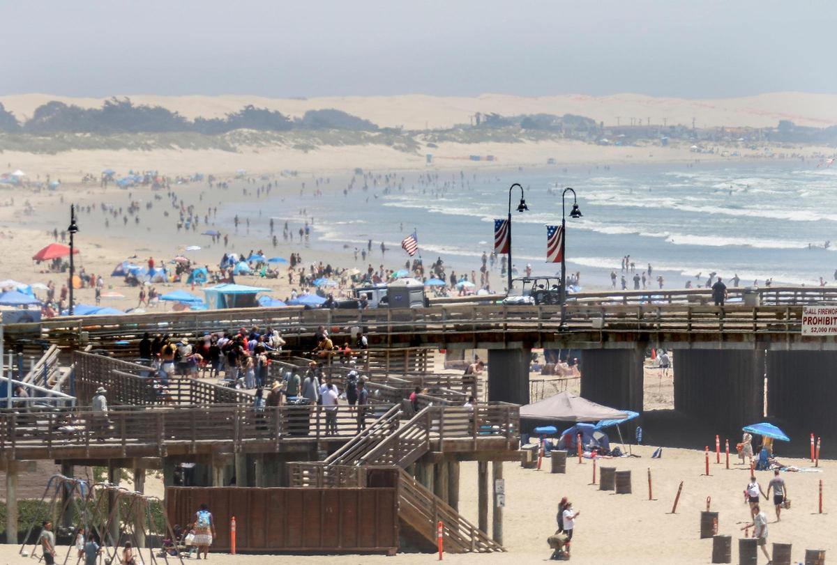 San Luis Obispo County beaches were not closed for the Fourth of July weekend during the 2020 coronavirus pandemic. A telephoto lens view looking south at the Pismo Beach Pier boardwalk.