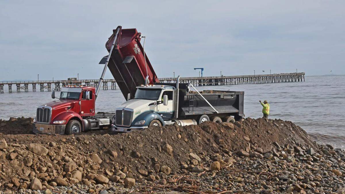 Trucks dump loads of mud, silt and rocks at Goleta Beach County Park.