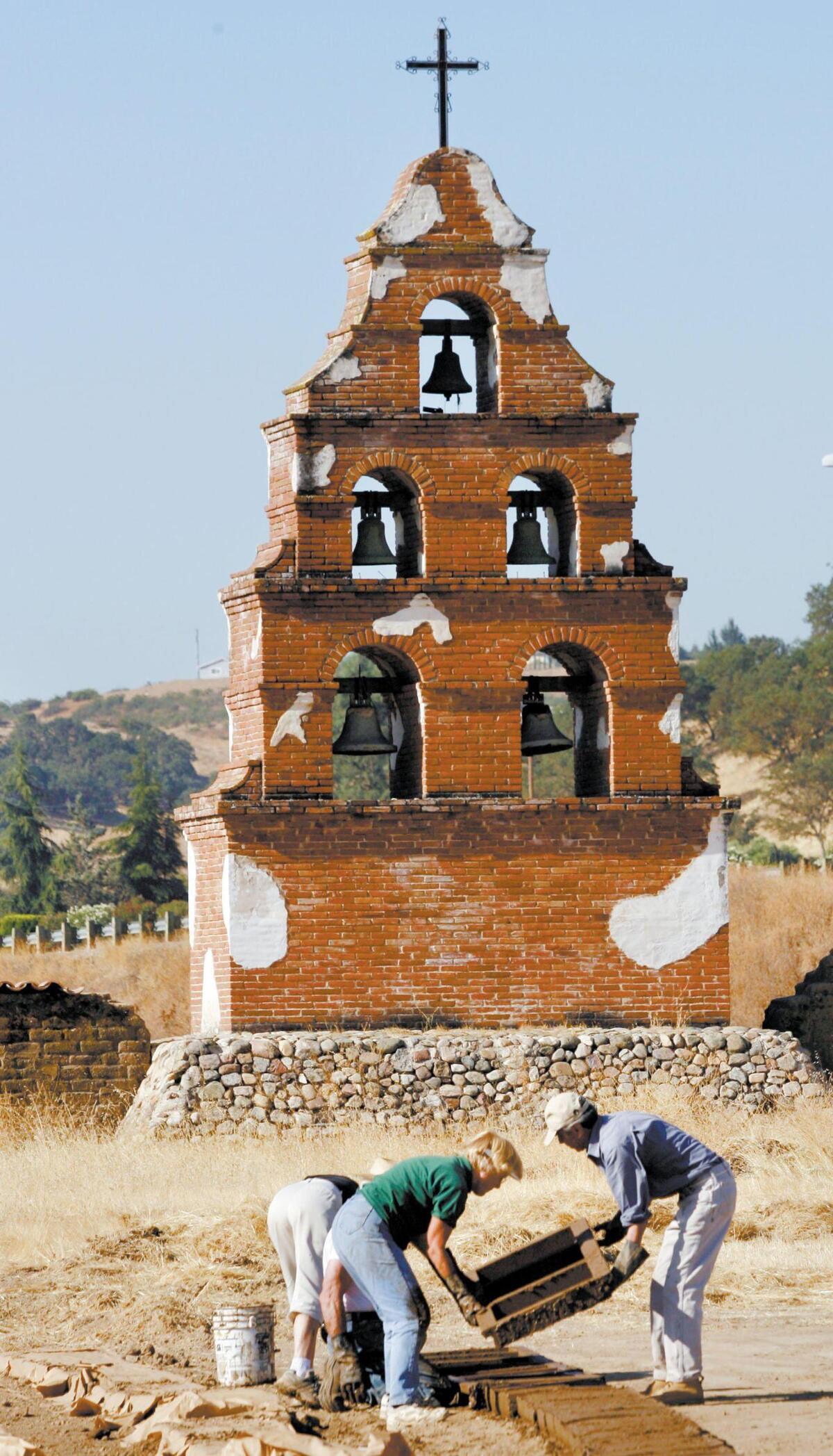 Jean Hoffmann and Tim Agular lift a frame away from new adobe bricks. They will be used in the earthquake damaged Mission San Miguel Aug. 28, 2006.