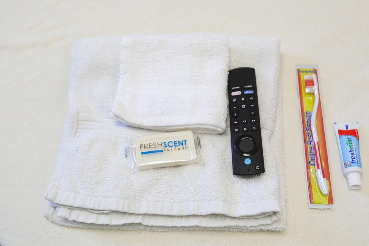 San Luis Obispo County opened a new sobering center on June 21, 2024. The center will be a bridge between the immediate need for a safe place to get sober and longer-term services. Toothbrush, toothpaste soap and towels sit on a bed. The remote operates a common room television.