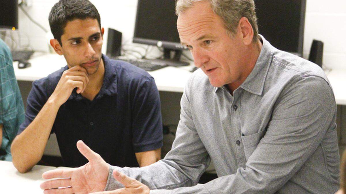 Former state Sen. Sam Blakeslee, right, talks to software designers at Cal Poly, including software developer Justin Rovin, left.