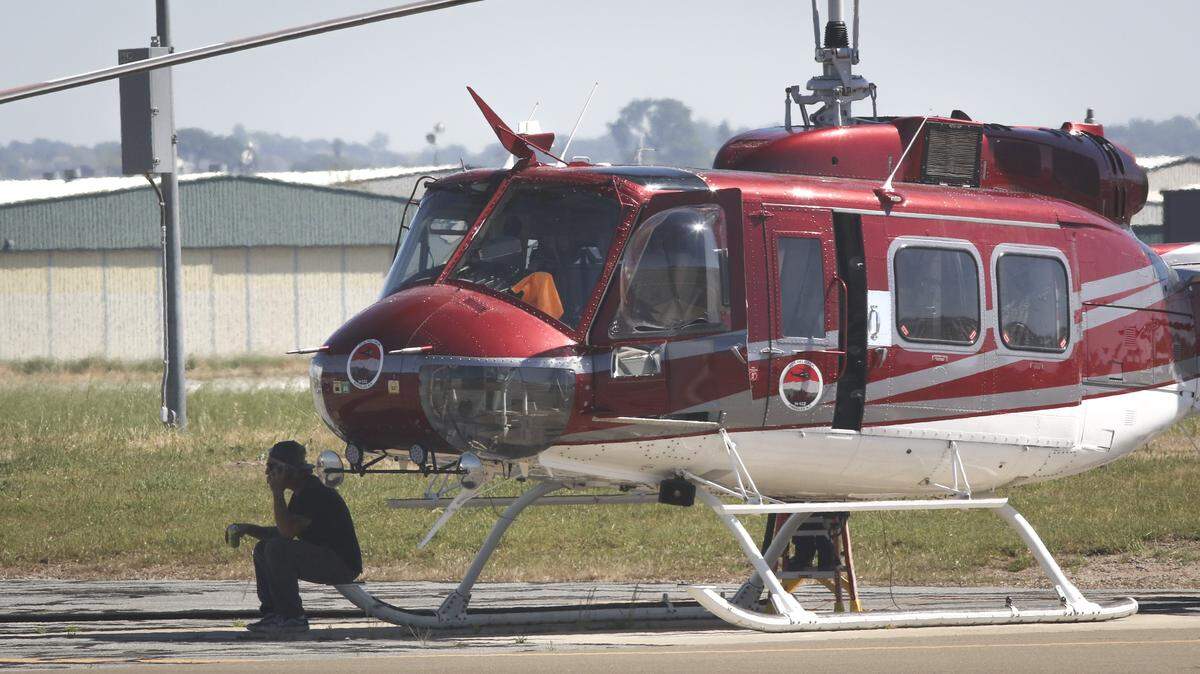 Pilot Mike Klink sits and enjoys a water in the shade while Lloyd’s Aviation refuels his helicopter on March 19, 2026 at Paso Robles Municipal Airport.