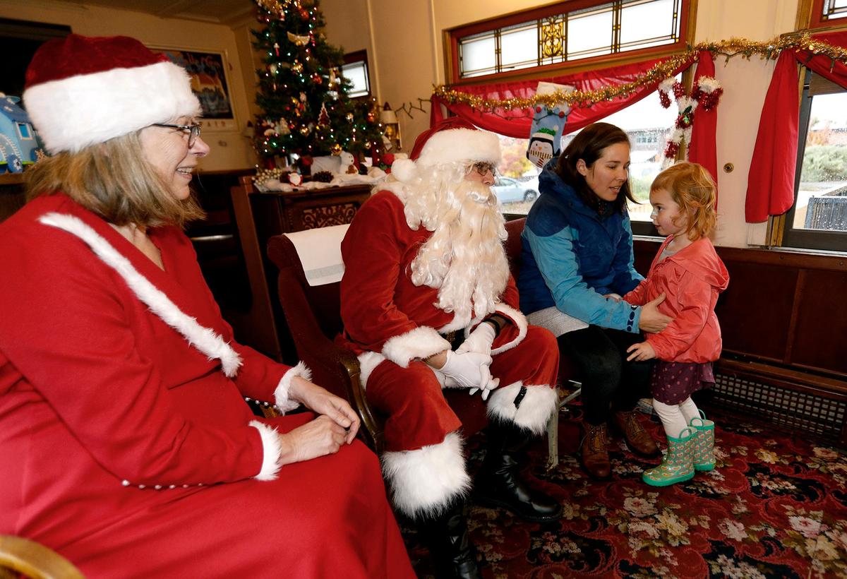 Sierra Layous lifts her daughter Charlie, 3, of San Luis Obispo to talk to Santa Claus, aka Paul Deis of Cambria, at the San Luis Obispo Railroad Museum on Dec. 7. Deis and his wife, Dorothy Deis, who stood in for Mrs. Santa Claus, thrilled parents and children as they hopped off Amtrak Surfliner No. 763, then were carted to the museum to meet with children and take photos.