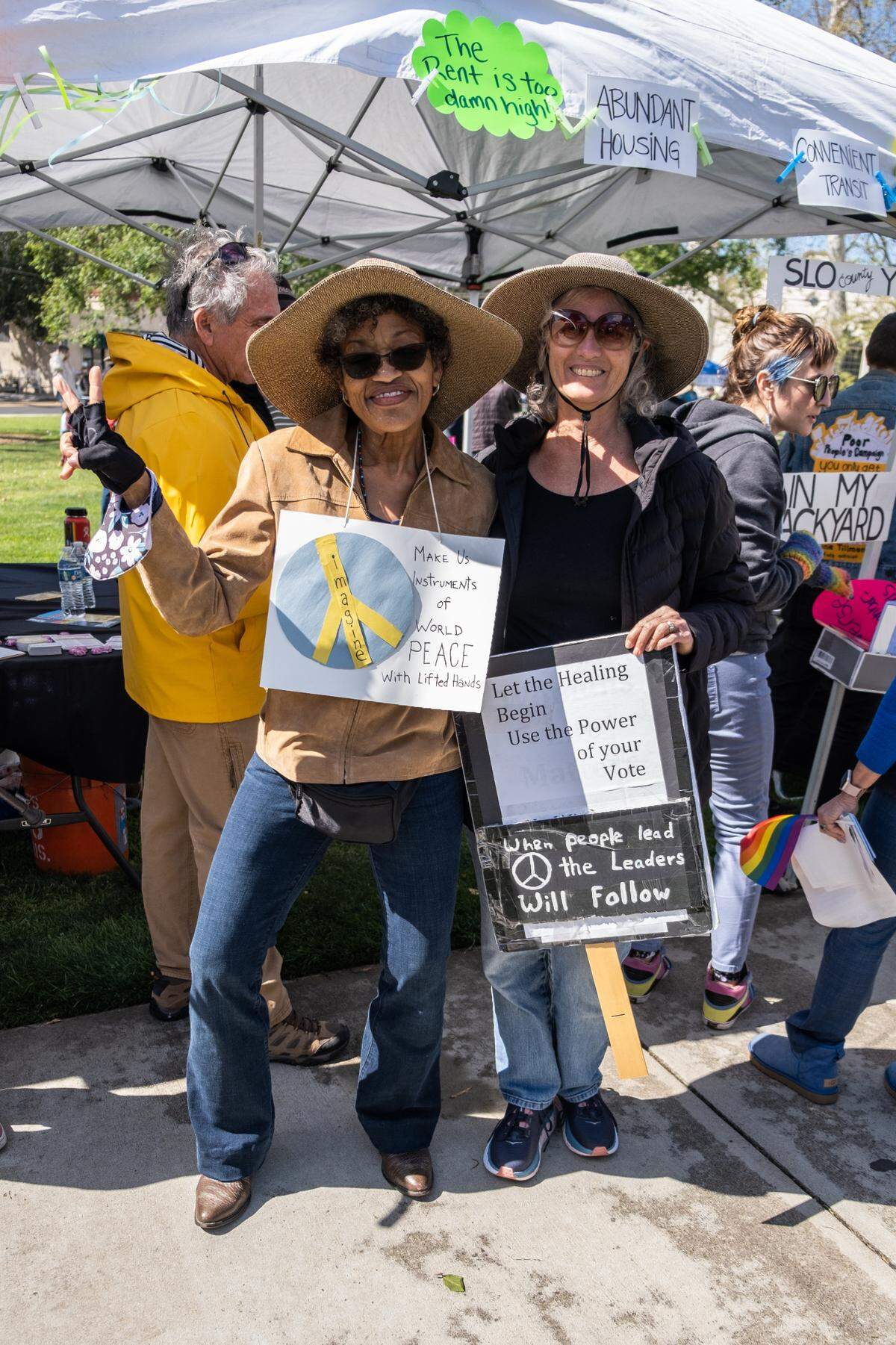Toni Boykin, left, and Karen Burish Wyke pose with their signs at the Engage for Equity rally organized by Women’s March SLO in San Luis Obispo on March 5, 2022.