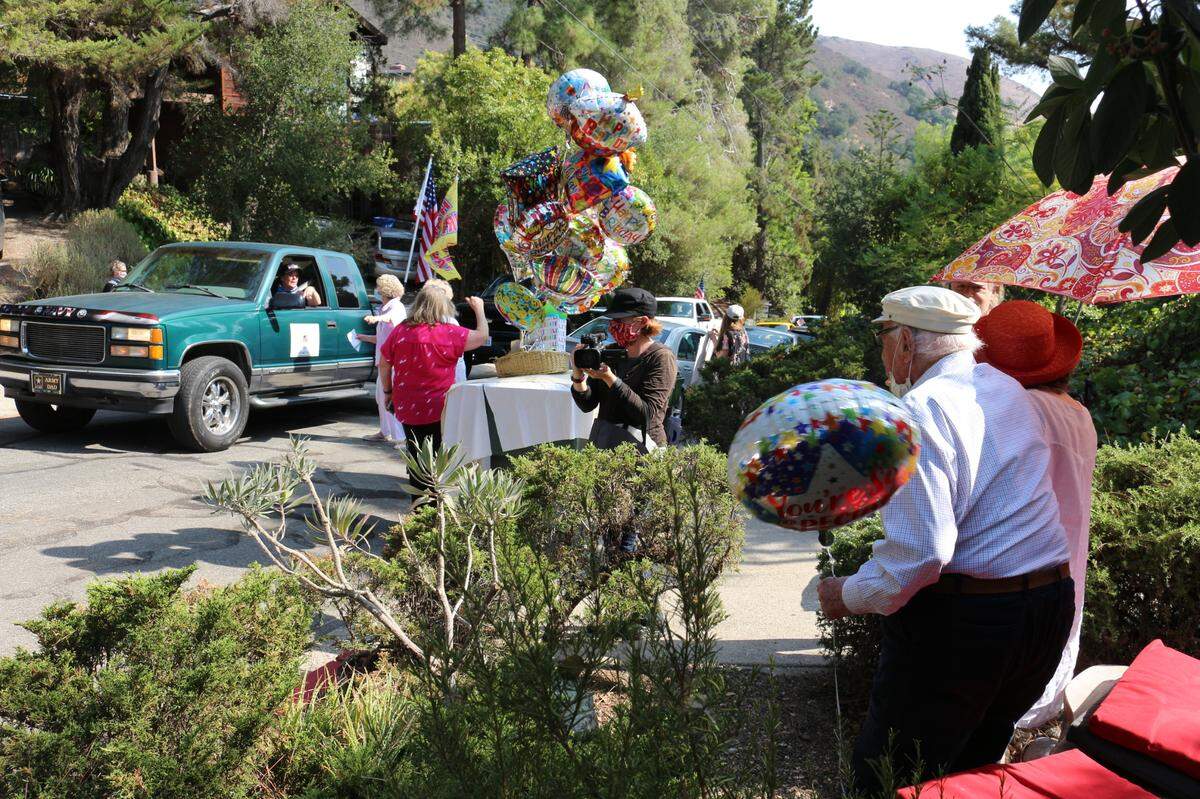 Dr. Joseph Abrahams and his wife, Elisabeth, wave to members of Welcome Home Military Heroes as they celebrate Abrahams’ 104th birthday on Sunday in San Luis Obispo.