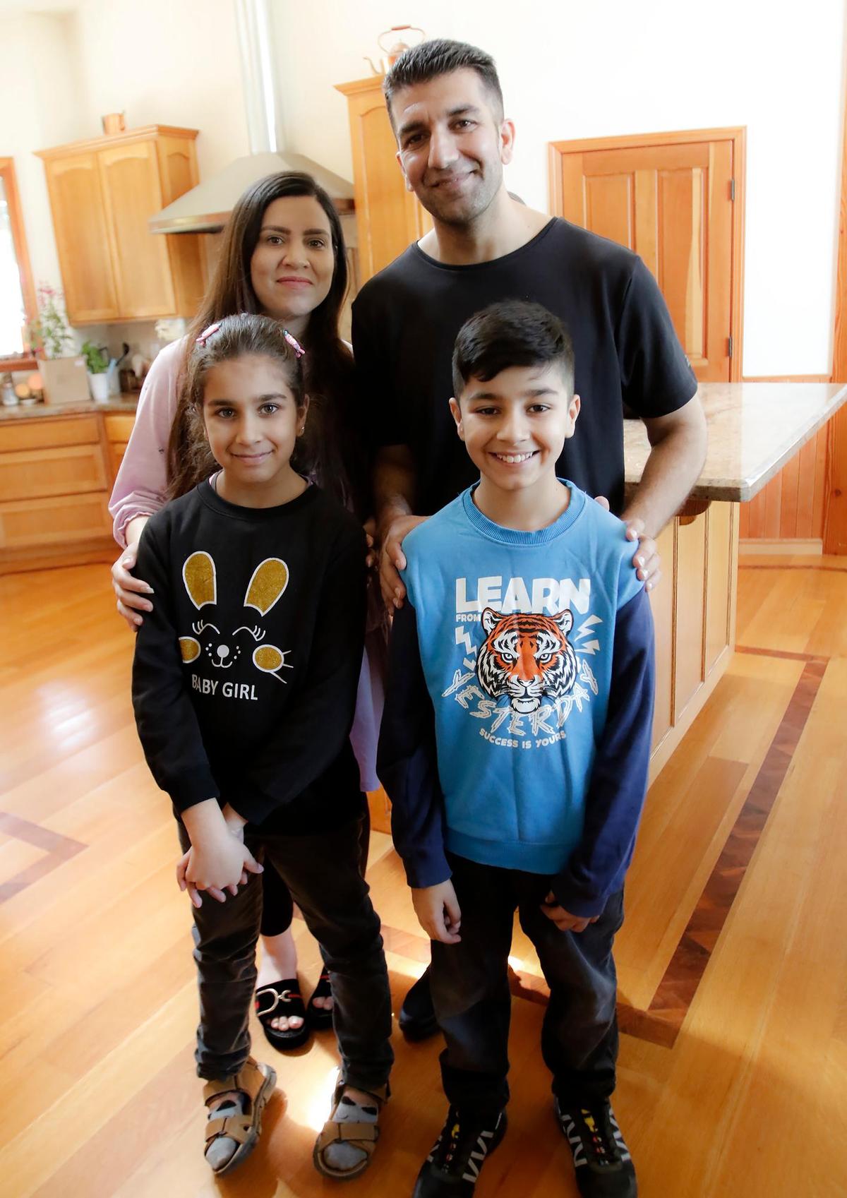 Negina Barakazai and her husband, Kawa Barakazai, pose for a picture with their 8-year-old daughter Maryam and 12-year-old son Ben Yamin in their new Cambria home. The Barakazai family spent more than two years in hiding in Afghanistan and Pakistan before arriving in the United States on Sept. 6, 2023.