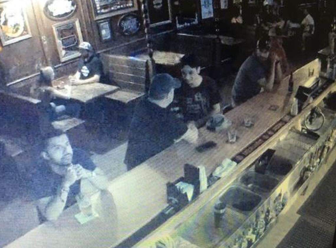 David Allen Knight (center, in hat) is seen in surveillance footage buying whiskey for Thomas Jodry at Frog & Peach Pub in San Luis Obispo on Sept. 14, 2019. Jodry died in a fall from a parking structure minutes after leaving the bar.