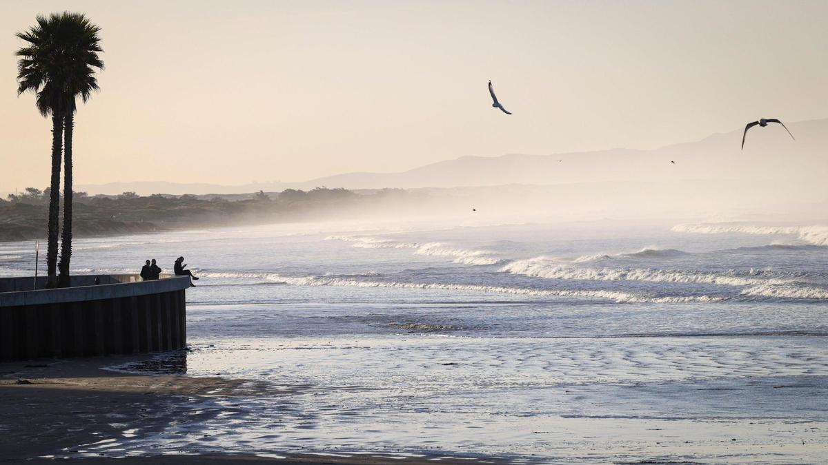 Beach goers stop to look over the 6.8-foot King Tide in Pismo Beach on the morning of Dec. 13, 2024.