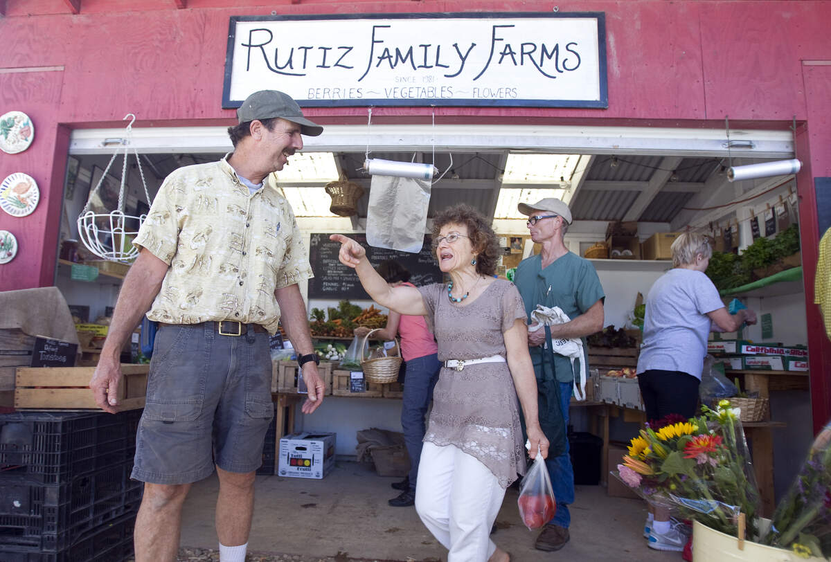 Gina Glass talks to Jerry Rutiz at the fruit stand in 2014.