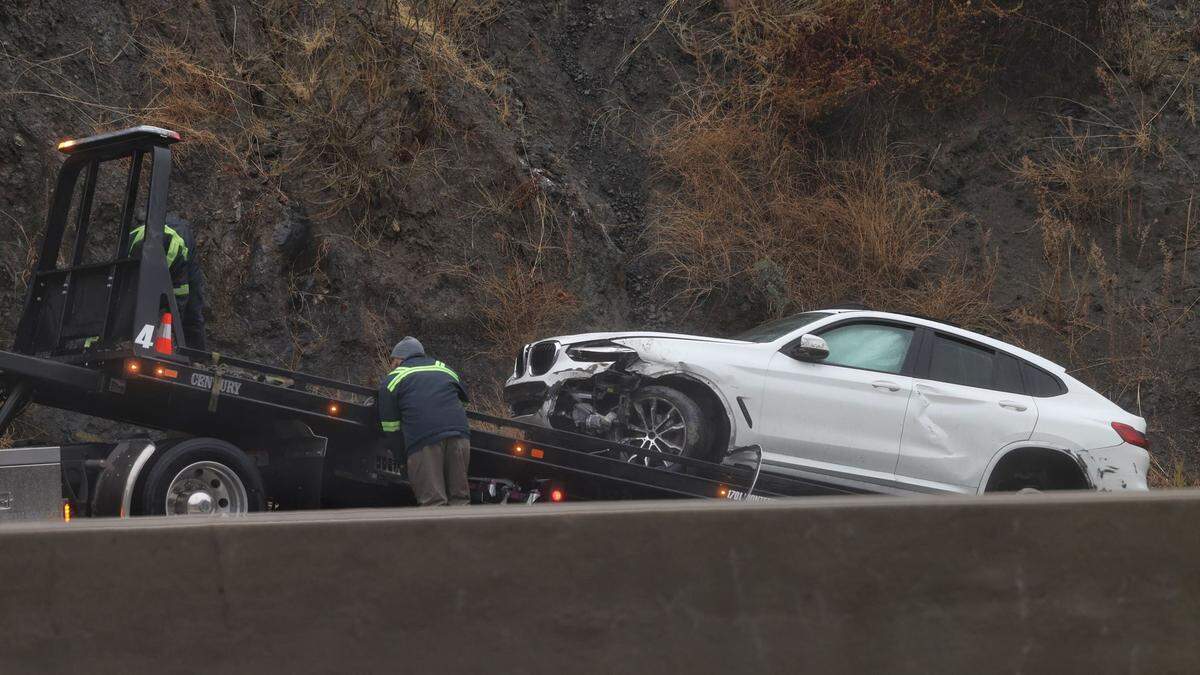 a damaged BMW is put on tow truck on southbound Highway 101 at the base of Cuesta Grade on Nov. 26, 2024. Two crashes due to heavy rain were reported on the grade.