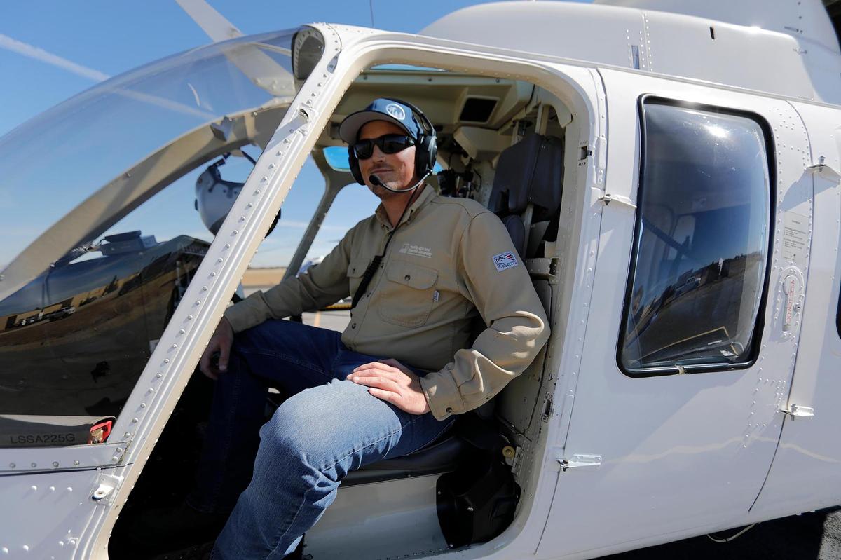 David Perry, supervising program manager at PG&E, sits in his usual spot aboard the helicopter that looks for problems and hazards around the the electrical towers in San Luis Obispo County. The utility was conducting aerial patrols in San Luis Obispo and Santa Barbara counties in October 2022 to reduce fire risk by identifying dead or dying trees near the lines.