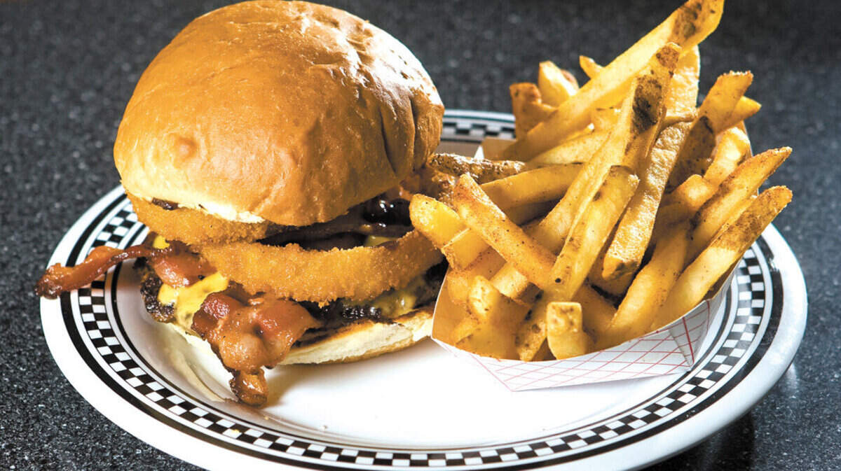 The Duke burger, served at Cool Cat Cafe in Pismo Beach, features two strips of bacon, melted cheese and golden onion rings and barbecue sauce.