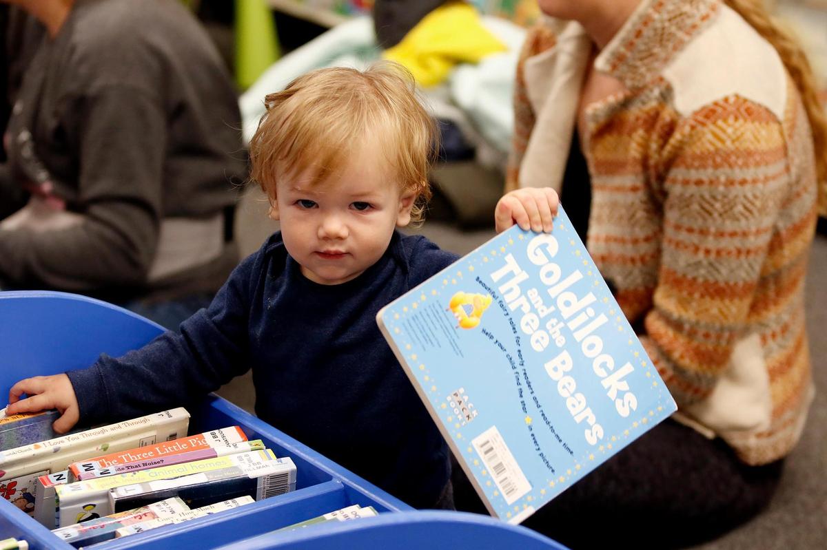 Children attend a lively story hour in the new Templeton Community Library, courtesy of retired librarian and volunteer story reader Kristen Barnhart. Weston Mendenhall, 11 months, of Creston is a future reader who enjoys classic books.