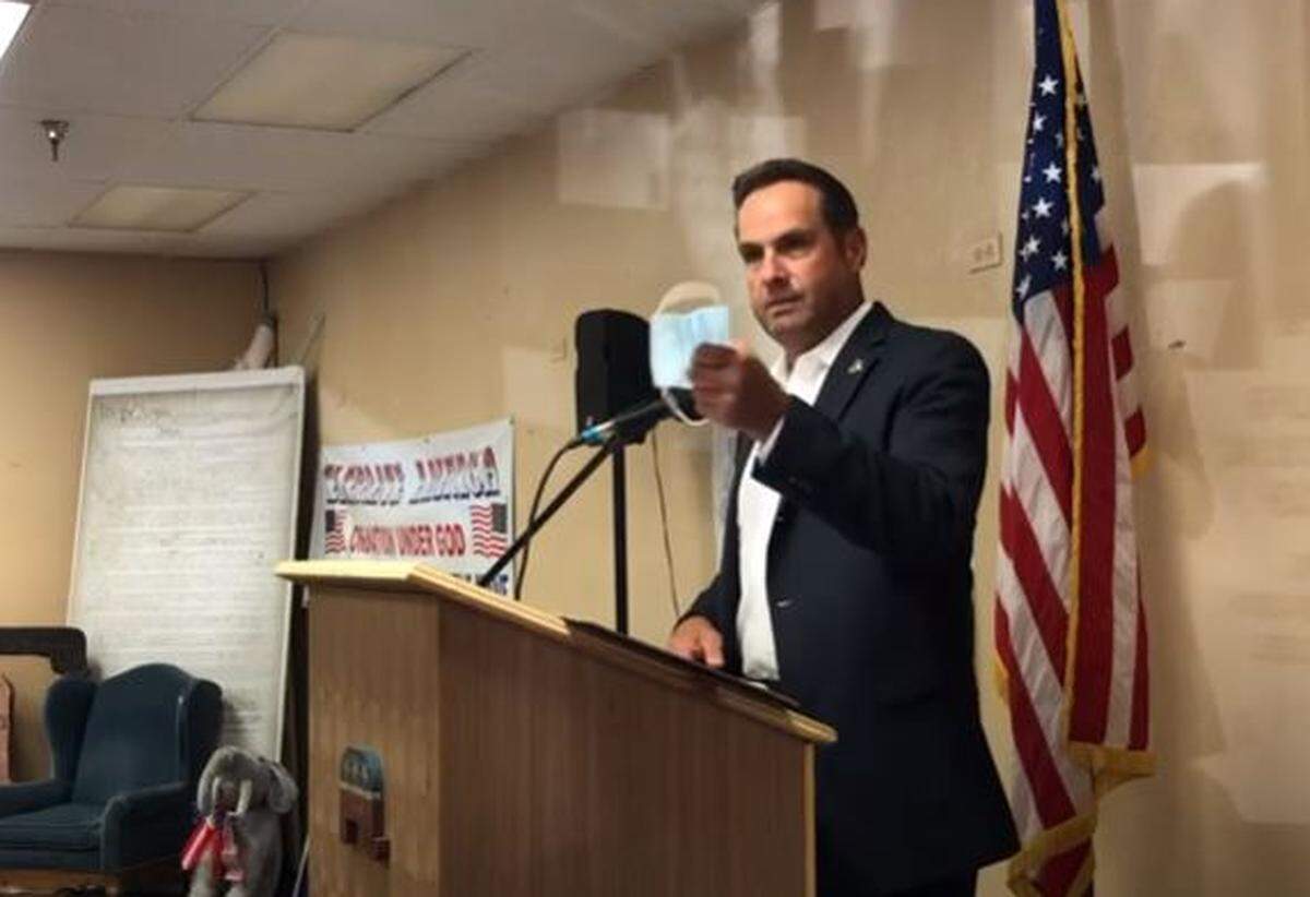 San Luis Obispo County Sheriff Ian Parkinson holds up a face mask during a speech to the North County Tea Party on July 6, 2020.