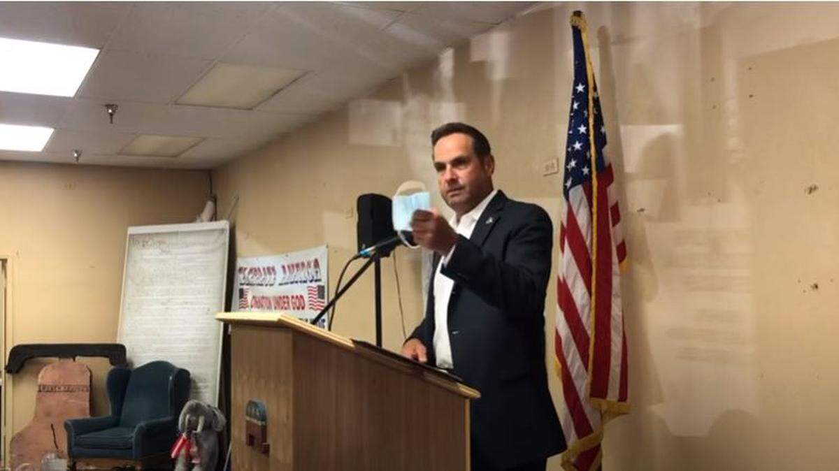 San Luis Obispo County Sheriff Ian Parkinson holds up a face mask during a speech to the North County Tea Party on July 6, 2020.