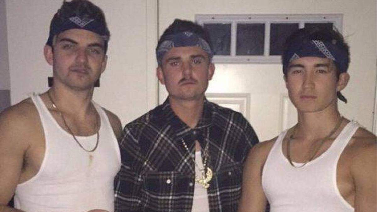 A photo shared on social media Tuesday, April 17, 2018, appears to show three Sigma Nu fraternity members dressed in bandanas, baggy pants, white ribbed tank tops, chains and a fake mustache.