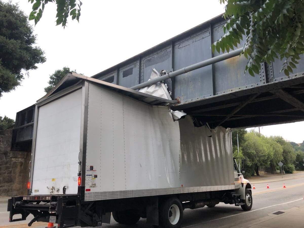 A delivery truck carrying equipment for Cal Poly’s graduation ceremonies got stuck under a railroad overpass on Highland Drive on Wednesday night.