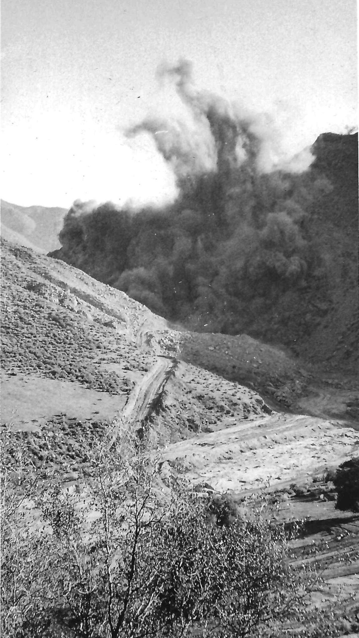 BLAST - The charge that kicked this huge plume of dust into the air over the Cuyama River gorge was compounded of ammonium nitrate and diesel oil. Story published May 22, 1971, on the construction of Highway 166.