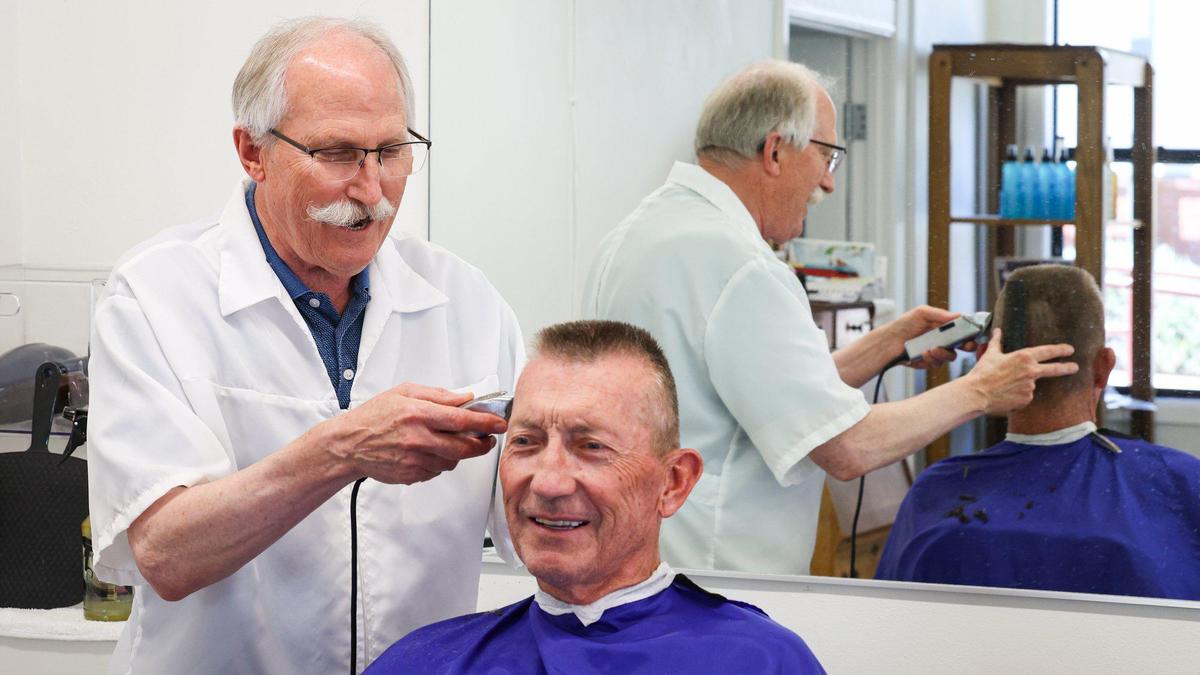 Ray Shearer has been a barber at the Anderson Barbershop for over half of its 100-year history. Mike Symons of San Luis Obispo gets a haircut. The barbershop is at a temporary location on Dana St. while the historic building is renovated.