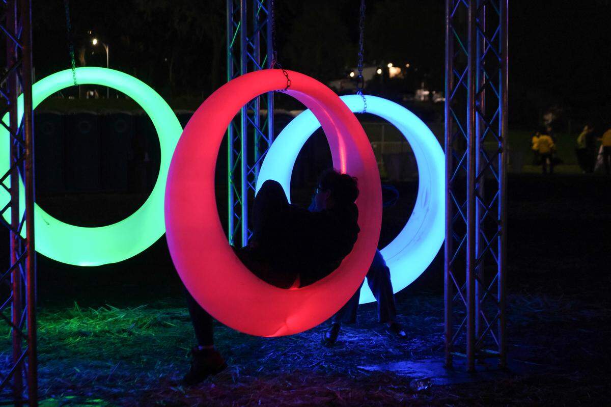 Cal Poly students lounge on light up swings at the university’s “Morning on the Green” music festival on March 15, 2025. The university organized the festival to give students an alternative to partying in neighborhood streets for St. Fratty’s Day.