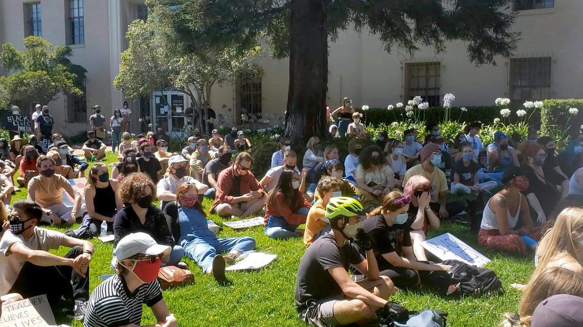 Protesters rest on the San Luis Obispo County Courthouse lawn while listening to speakers after the silent sit-in on July 25.