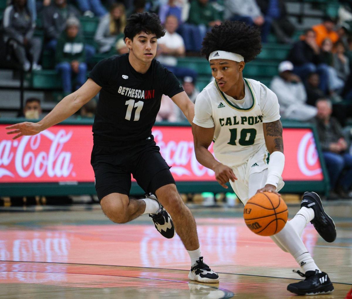 Isaac Spears drives with the ball while guarded by Adrian Hernandez. Cal Poly basketball opened its season with a 94-59 win against Bethesda University on Nov. 7, 2022.