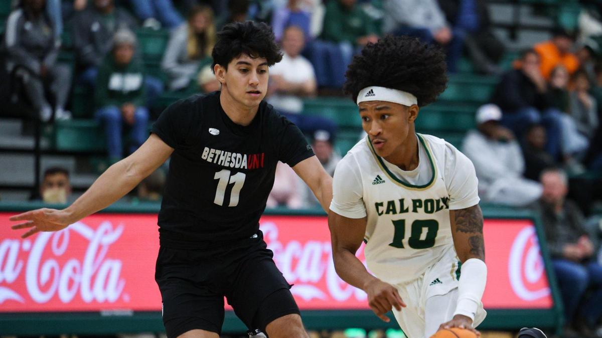 Isaac Spears drives with the ball while guarded by Adrian Hernandez. Cal Poly basketball opened its season with a 94-59 win against Bethesda University on Nov. 7, 2022.
