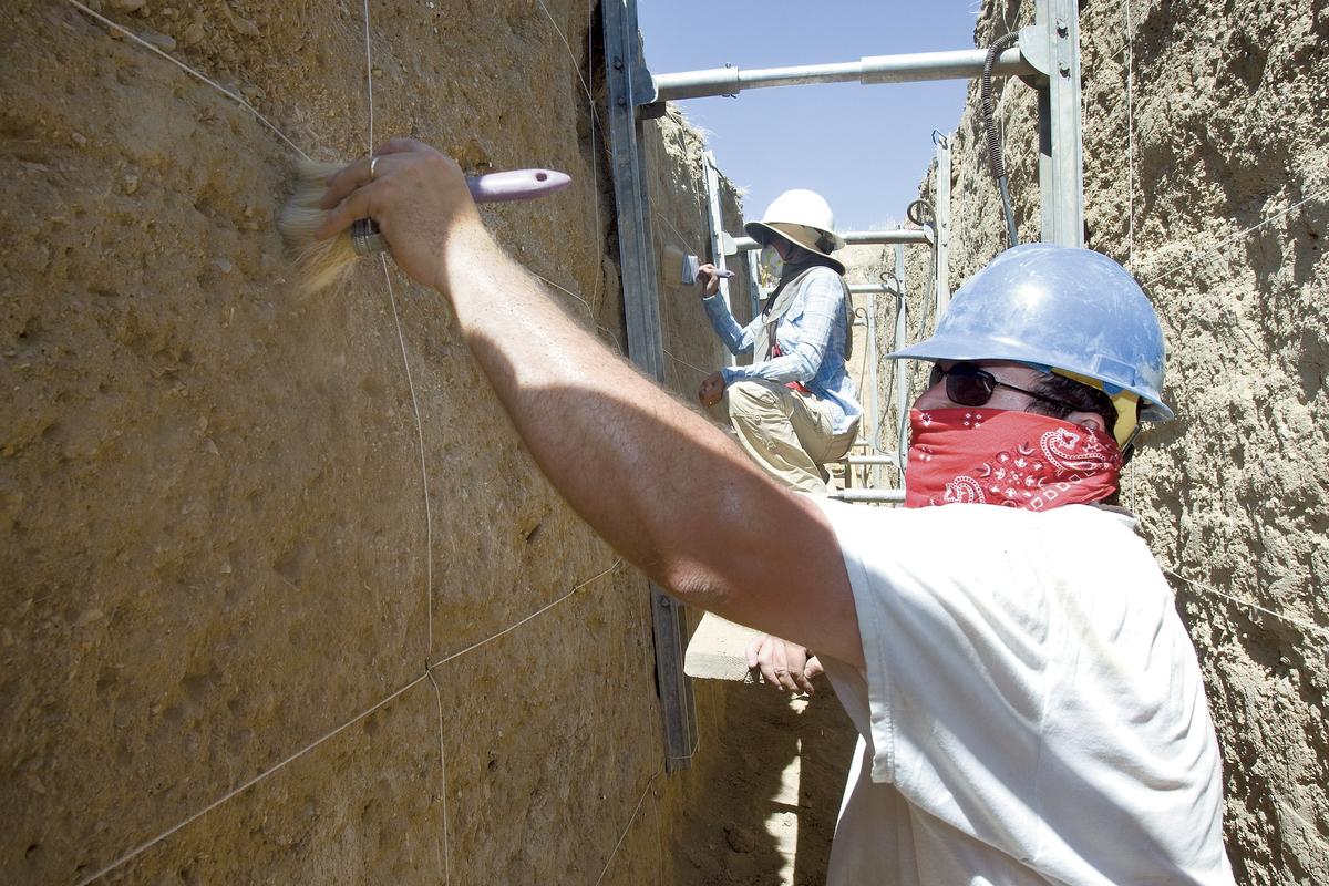 David Haddad, a PhD candidate from Arizona State University, wears a mask to guard against Valley Fever as he smooths the wall of a trench before it is photographed July 29, 2011. The movement of the San Andreas fault is being documented at Wallace Creek by a research team. The location on the Carrizo Plain has been a favorite of researchers for decades.