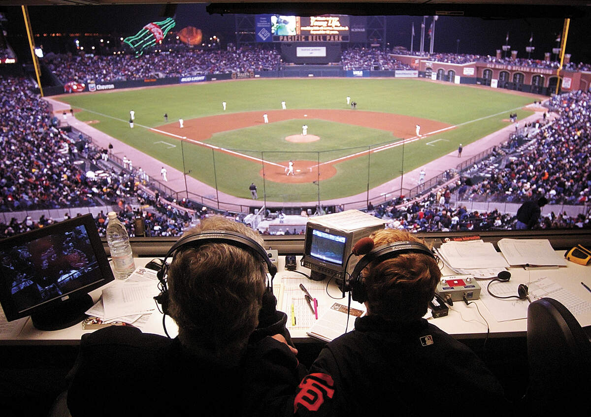 Mike Krukow and son Chase, 14, watch a game at Pacific Bell Park as the San Francisco Giants host the Arizona Diamondbacks on July 16, 2002. Unlike most fathers and sons at the ballpark, Chase uses headphones to listen to his dad analyze the game as he broadcasts.