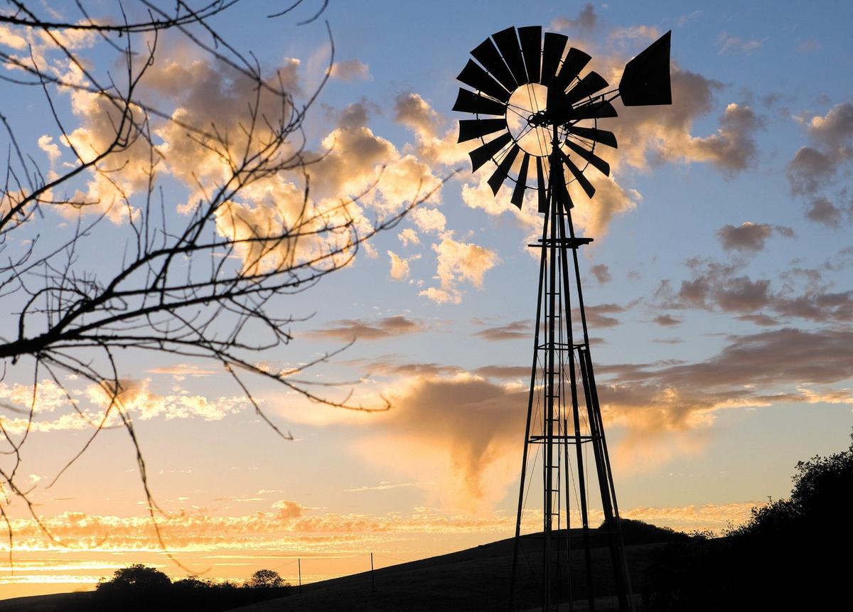 A windmill stands against incoming clouds and sunset along Highway 41 between Creston and Atascadero on Nov. 10, 2013.