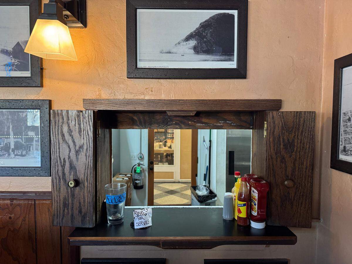 Savory Smoke, a new Morro Bay barbecue restaurant, fulfills food orders to bar patrons at Legends through this connecting window.