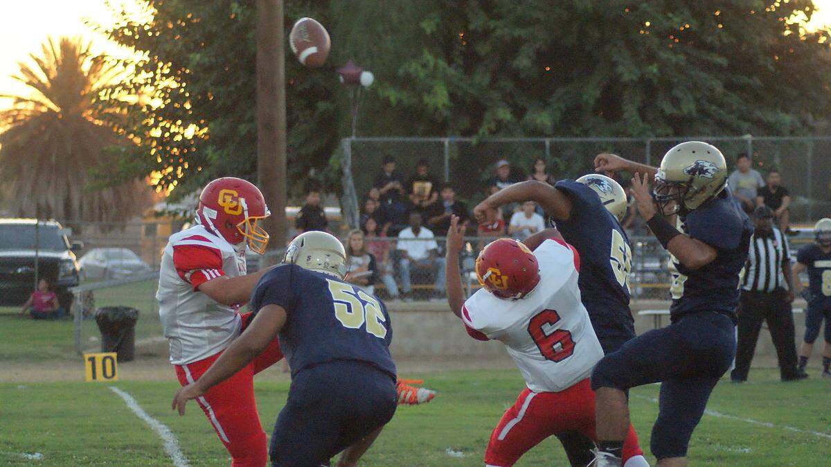 Bronco quarterback Emany Plasencia, who serves as punter, has his kick blocked by the Laton High School Mustangs Friday night September 7.