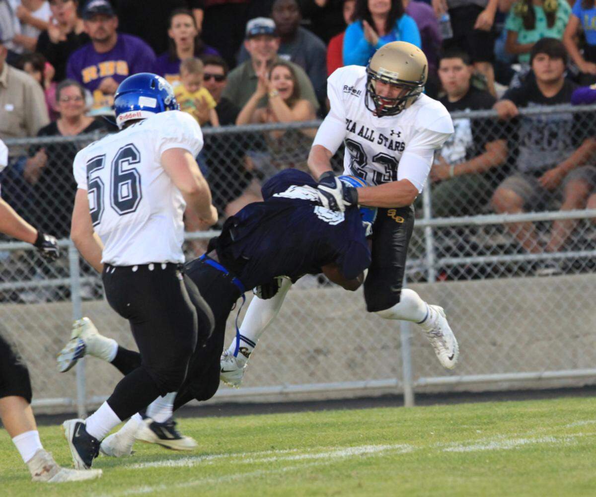 San Luis Obispo County’s Daniel Perlette (56) of Morro Bay High and Patrick Laird (23) of Mission’s Prep combine on a stop of Northern Santa Barbara’s A.J. Flores of Lompoc during the FCA All-Star game in Paso Robles in 2014.