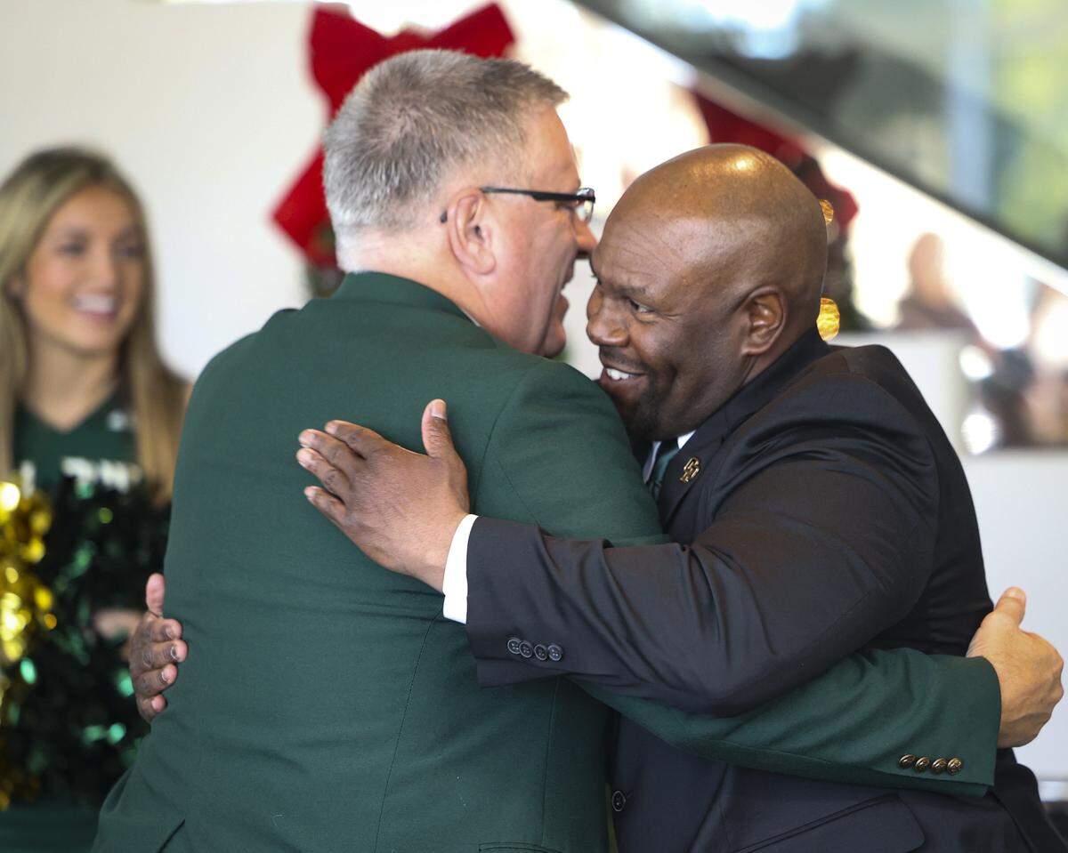 Cal Poly President Jeffrey Armstrong hugs new football head coach Tim Skipper on Dec. 8, 2025.