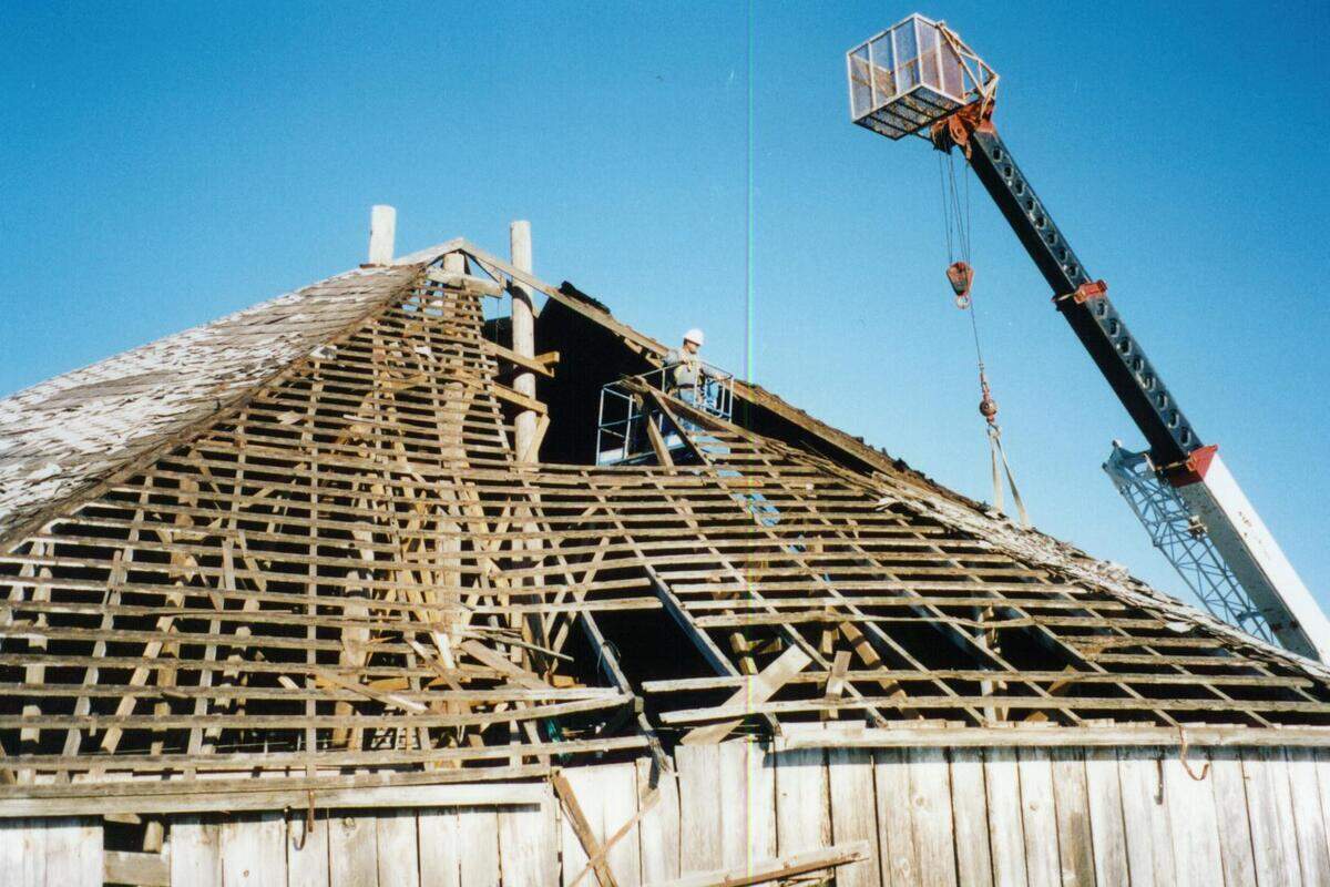 A construction crew works on the restoration of the Octagon Barn’s roof.