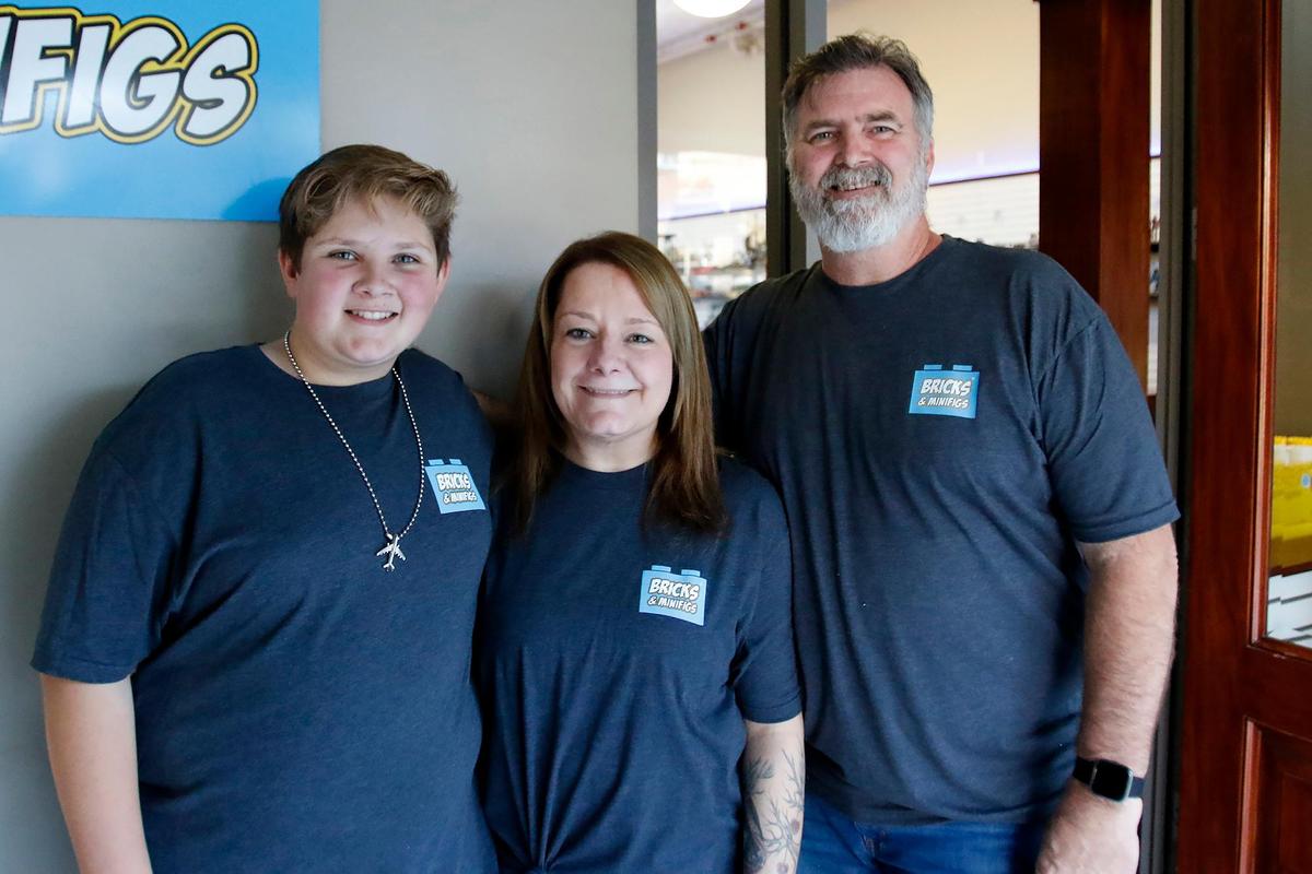 Owners, Shannon and Bo Schmidt and Kyle, age 12, stand in front the packed store. A new Lego store named Bricks & Minifigs, which sells and trades used Lego bricks and minifigures, held a soft opening in San Luis Obispo, Saturday, Nov. 19. 2022. The grand opening will happen early next year.
