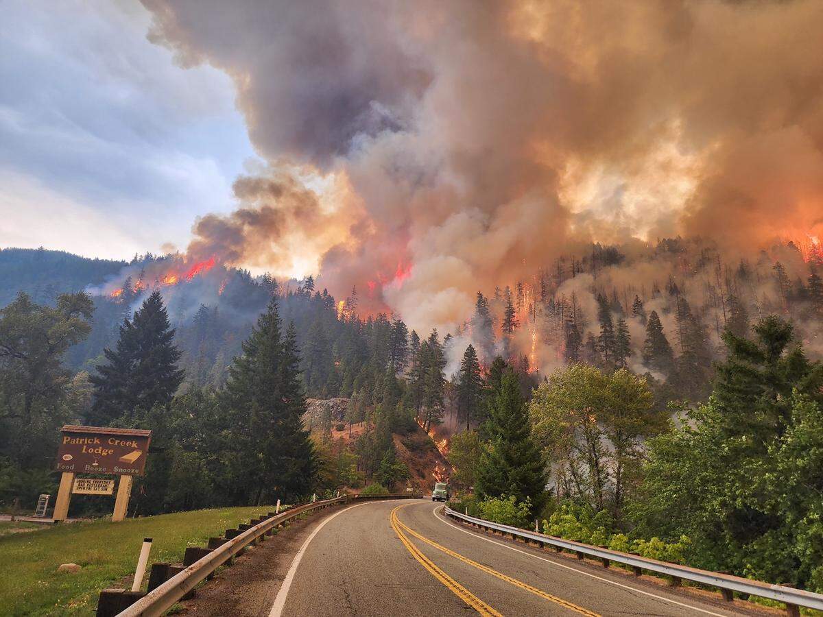 The Smith River Complex fire burns here on Aug. 17, 2023, near the Patrick Creek Historic Lodge along Highway 199 in Northern California.