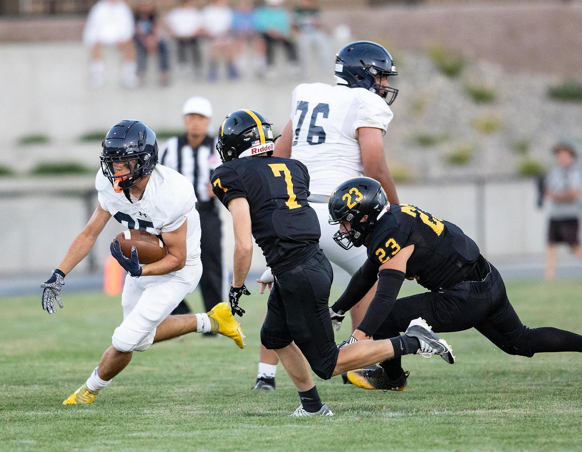 Arroyo Grande’s Junior Herlihy (25) tries to avoid San Luis Obispo’s Riesen Carlberg (7) and Mack Garcia (23). Arroyo Grande beat San Luis Obispo 26-14 on Friday, Sept. 2, 2022.