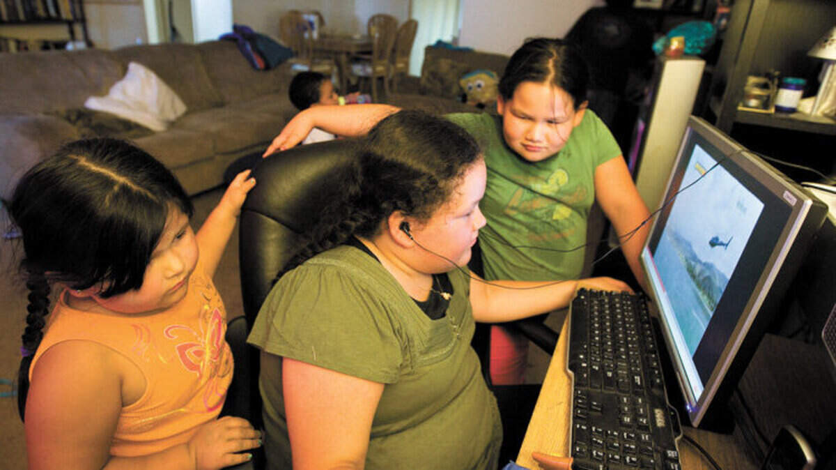 Mia Becerra, 5, left, and her sisters Rasaley, 10, Krysta 8, watch videos on their computer on a recent evening at their San Miguel home.
Photo by Joe Johnston  07-30-10  