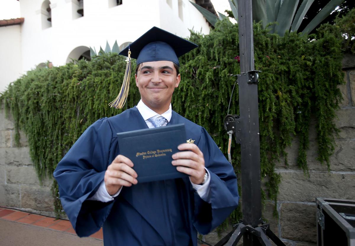Jaron Miles clutches his diploma and happily displays it to the crowd. Eighty-three Mission Prep students graduated in San Luis Obispo, earning nearly $2 million in scholarships.