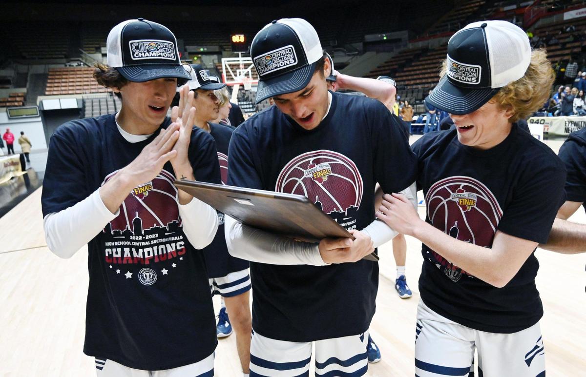 Arroyo Grande players gaze at the plaque after beating Porterville 59-30 to win the CIF Central Section boys Division 2 basketball championship Friday, Feb. 24, 2023, in Fresno.