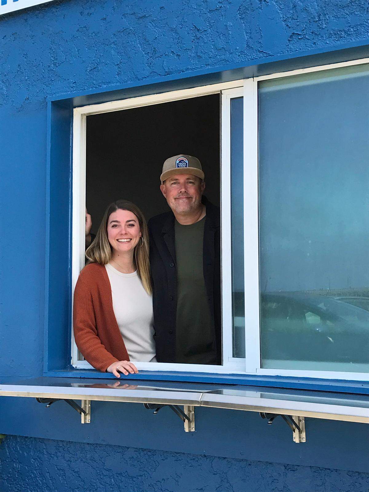 A North Coast couple practice standing in the order/takeout window in the beachfront spot in Cayucos where they’ll soon open their new Pie in the Sky Pizza spot. It will offer slices and whole pizzas, Ellen and Jeremy Sizemore said Saturday, Aug. 3, 2024, of their plans for the take-out eatery location where pizzas been sold for years.
