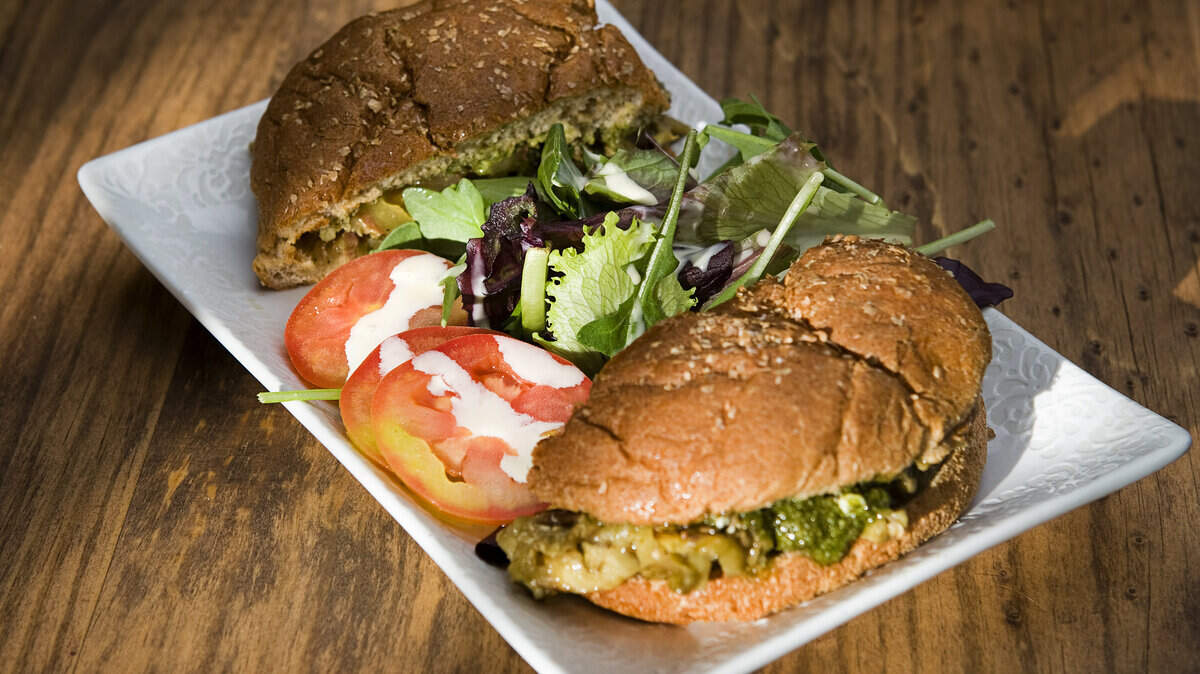 The eggplant burger features caramelized onions, tomato, goat cheese and pesto at Harmony Cafe. 